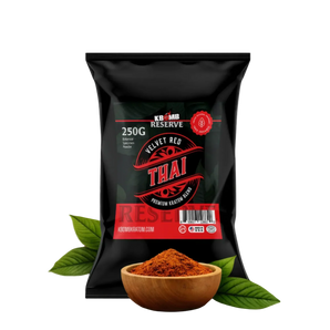 Black package of Velvet Red Thai spice with a wooden bowl of spice and leaves on a white background